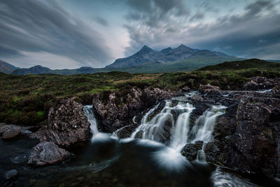 Scenic view of waterfall against sky