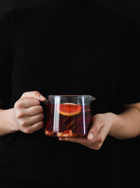 Midsection of man holding wine glass