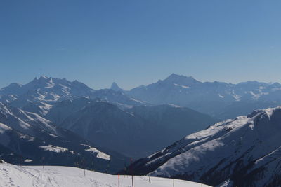 Scenic view of snow covered mountains against cloudy sky