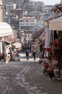 People walking on street amidst buildings in city