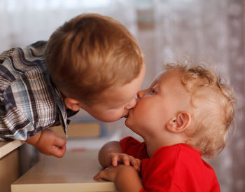 Cute brothers kissing at home