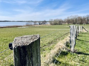 Wooden fence on field against sky