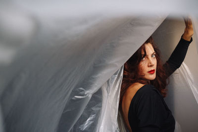 Portrait of beautiful woman standing by plastic