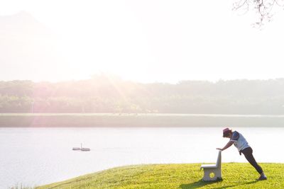 Man in lake against clear sky