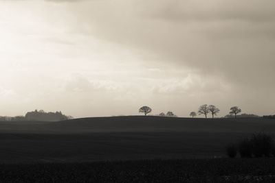 Scenic view of field against cloudy sky