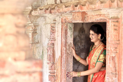 Rear view of woman standing in abandoned building