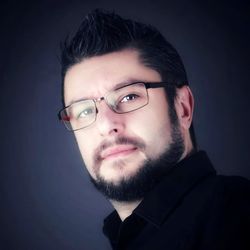 Portrait of young man against black background