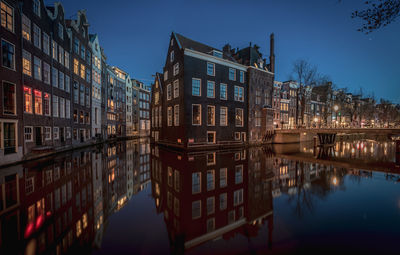 Reflection of buildings in canal at dusk