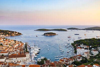 High angle view of townscape by sea against sky during sunset