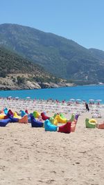 Deck chairs on beach against blue sky