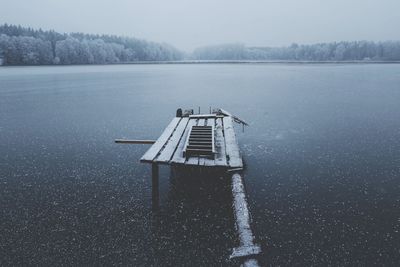 Built structure on frozen lake against sky