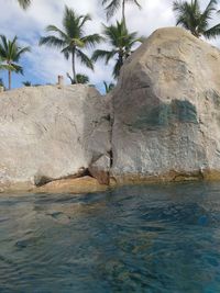 Rock formation in sea against sky