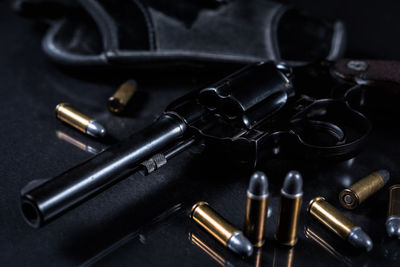 Close-up of bullets and handgun on table