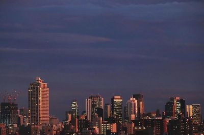 Illuminated buildings in city against sky