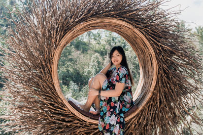 Portrait of happy woman sitting in wooden decoration