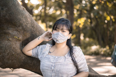 Portrait of woman against tree