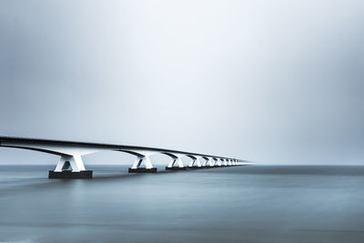 Bridge over sea against sky