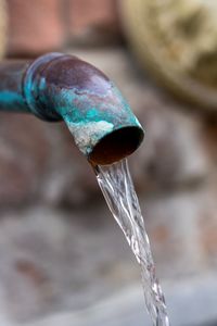 Close-up of water drop falling from pipe