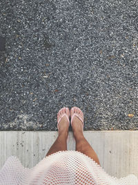 Low section of woman standing on road