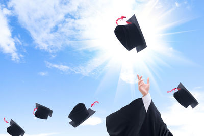 Low angle view of man throwing mortarboard