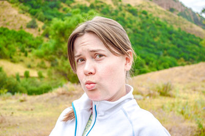 Portrait of young woman standing on field