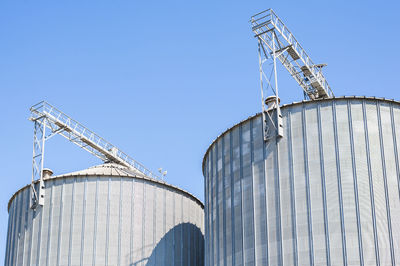 Low angle view of factory against clear blue sky