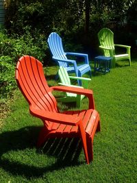 Empty chairs against trees on grass