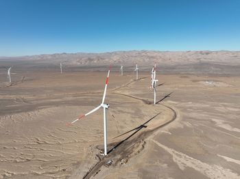 Low angle view of windmill against clear blue sky