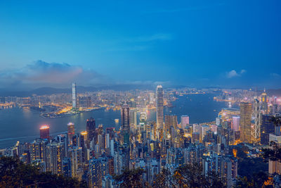 Illuminated modern buildings in city against sky