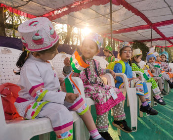 Cute kids wearing costume sitting on chair outdoors