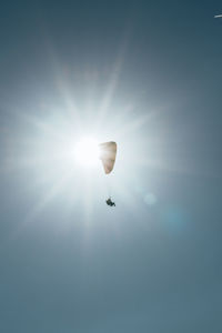 Low angle view of person paragliding against sky