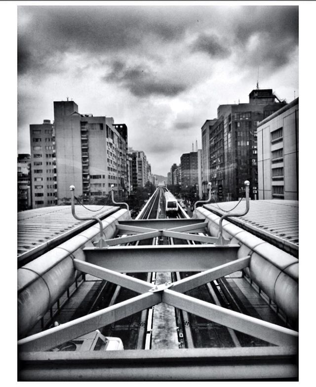 architecture, building exterior, built structure, sky, transfer print, city, transportation, cloud - sky, diminishing perspective, auto post production filter, the way forward, cloudy, building, cloud, day, vanishing point, railroad track, outdoors, no people, overcast