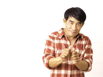 Portrait of young man standing against white background