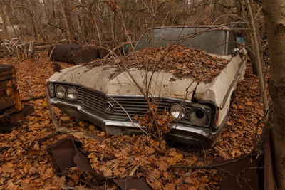 Damaged car on field during autumn