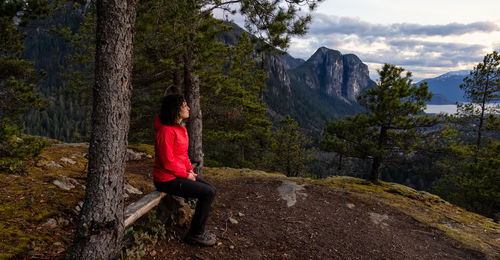 Woman on mountain road amidst trees in forest