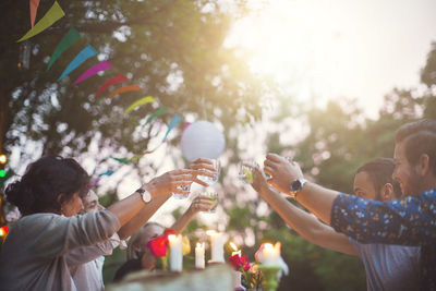 Multi-ethnic friends toasting drinks at garden party