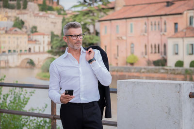 Businessman using mobile phone while standing outdoors