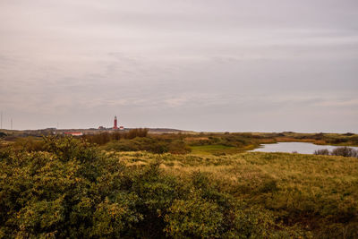 Scenic view of landscape and lighthouse against sky