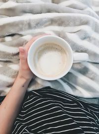 Low section of woman holding coffee cup