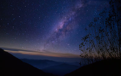 Scenic view of silhouette mountain against sky at night