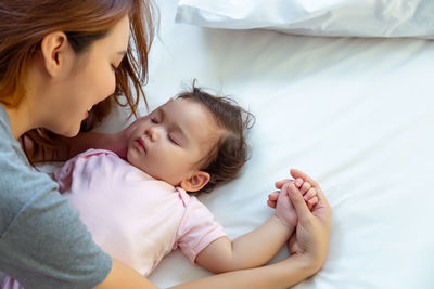 Mother and baby girl on bed