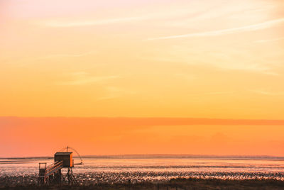 Scenic view of sea against orange sky