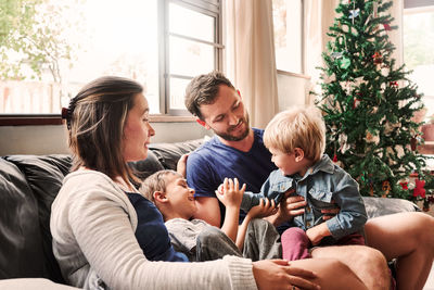 Parents and kids sitting on sofa at home