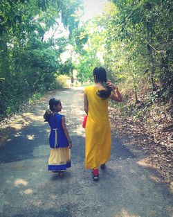 Rear view of women standing on tree