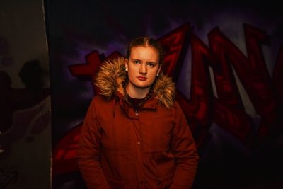 Portrait of beautiful young woman standing at night