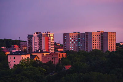 Buildings in city against sky at sunset