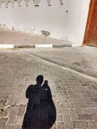 Shadow of people on street in city