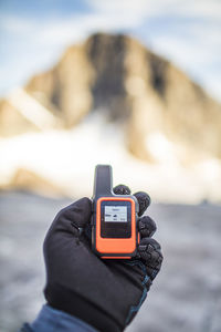 Hiker holding gps device in the mountains.