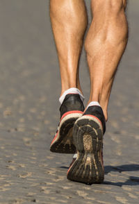 Low section of man skateboarding on beach