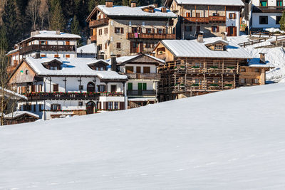 High angle view of snow covered houses and buildings in city